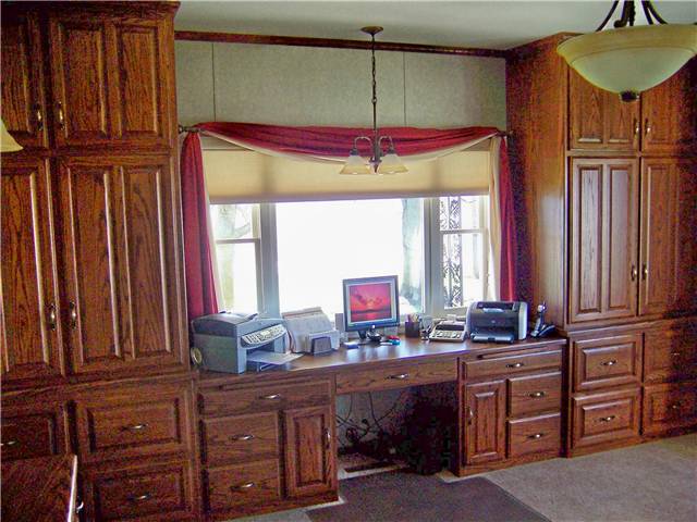 Oak computer desk with tall storage cabinets and file drawers. Office of an insurance agency.
